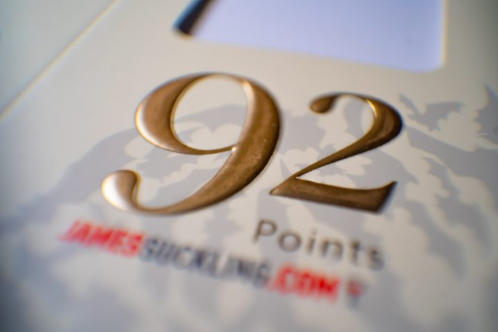 Detalle de estampado en foil dorado con la puntuación "92 Points" sobre un estuche blanco