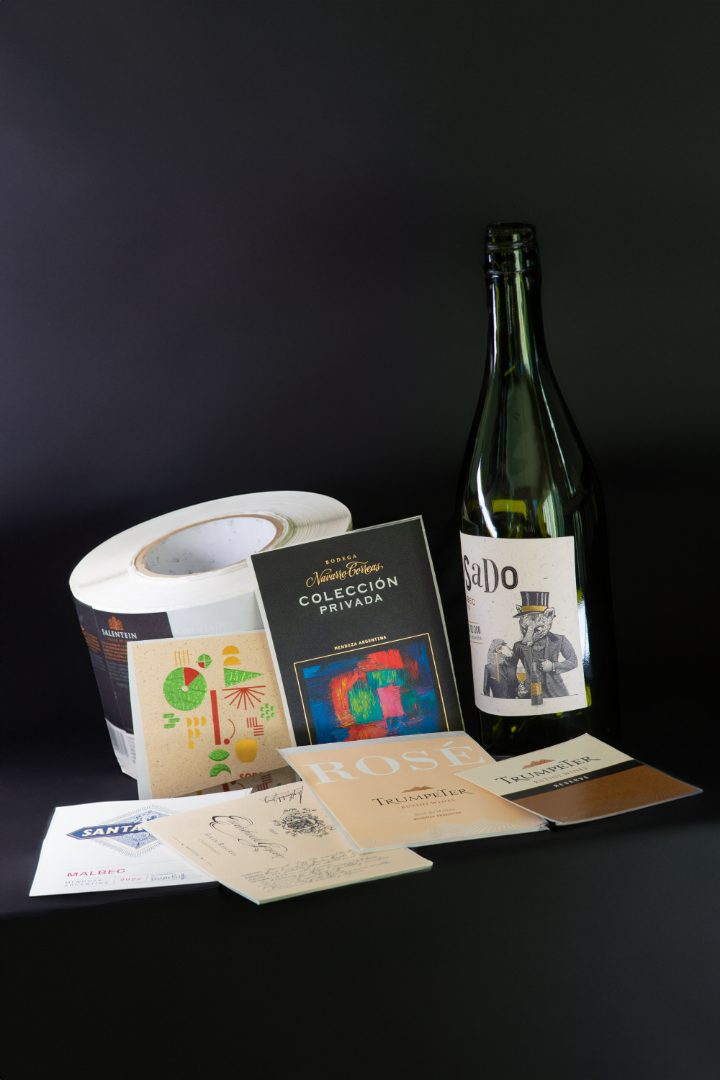 Rollos de etiquetas autoadhesivas junto a una botella de vino blanco